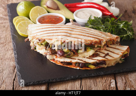 Quesadilla con carne macinata, fagioli, avocado e formaggio vicino sul tavolo orizzontale. Foto Stock