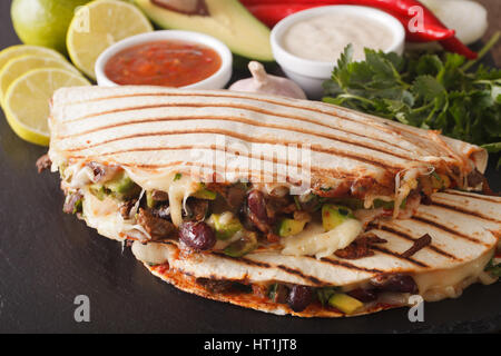 Cibo messicano: Quesadillas con carne di manzo, fagioli, avocado e formaggio vicino sul tavolo orizzontale. Foto Stock