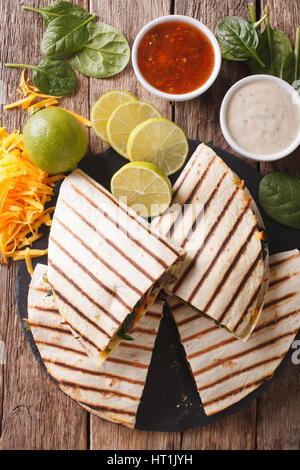 Grigliata di quesadilla con carne di manzo, spinaci e il formaggio cheddar vicino sul tavolo. vista verticale da sopra Foto Stock