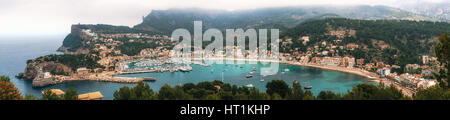 Vista panoramica di Port de Soller con Harbour, yacht e imbarcazioni turistiche, colorata architettura e la spiaggia in un giorno nuvoloso. Punto di riferimento di Mallorca, Spagna Foto Stock