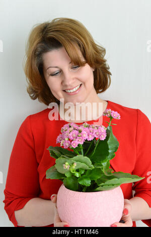 Una donna holding kalanchoe in una pentola Foto Stock