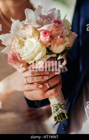 Sposa tenere wedding bouquet di rose peonie e rose. Mani vicino fino Foto Stock