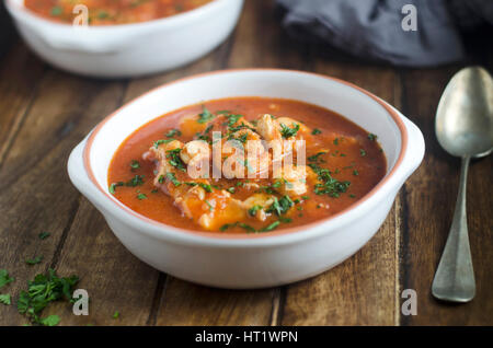 Ricca di pomodoro, vino e stufato di pesce Foto Stock