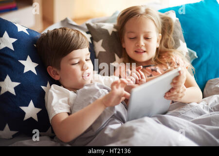 I fratelli trascorrere la mattina in bed Foto Stock