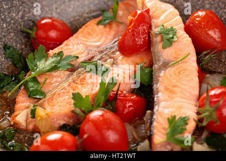 Closeup colpo di fritto bistecca di salmone con limone e verdure in padella. Foto Stock