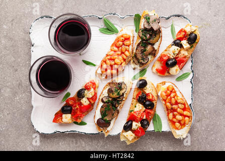 Spaghetti impostato per il vino. Varietà di piccoli panini con insalata caprese , fagioli bianchi alla griglia con salsa di pomodoro e di funghi fritti con soft chee Foto Stock