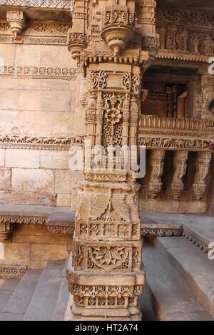 Scultura in pietra su un pilastro e pilastro. Adalaj Stepwell, Ahmedabad, Gujarat, India Foto Stock