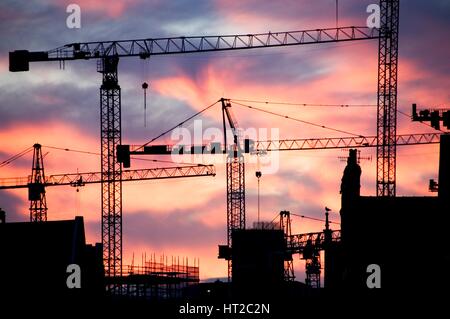 Un sito di costruzione al tramonto con gru stagliano contro un cielo rosso, 2007. Artista: Storico Inghilterra fotografo personale. Foto Stock