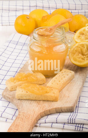 Fresche fatte in casa cagliata di limone in un bicchiere e pane appena sfornato scottish biscotto frollino Foto Stock