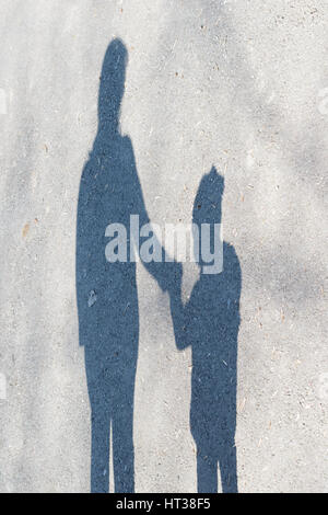 Le ombre delle donne ed un bambino piccolo su asfalto Foto Stock