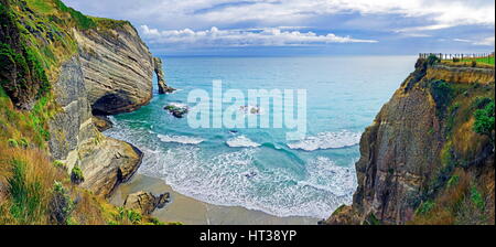 Ripida scogliera con arco di roccia e piccola spiaggia di sabbia, Capo addio, Mare di Tasman, Puponga, Isola del nord, Nuova Zelanda Foto Stock