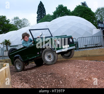 Bambino la guida un giocattolo di Land Rover. Artista: sconosciuto. Foto Stock