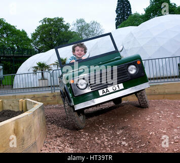 Bambino la guida un giocattolo di Land Rover. Artista: sconosciuto. Foto Stock