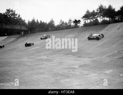 Invicta, Talbot e Frazer-Nash cars racing sui membri Banking di Brooklands. Artista: Bill Brunell. Foto Stock