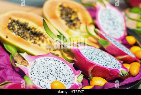 La sezione trasversale del drago di frutta o pitahaya con sullo sfondo la sezione trasversale di una papaia Foto Stock