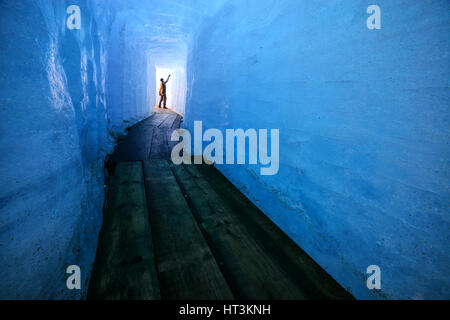 Silhouette uomo nella caverna di ghiaccio. Ghiacciaio del Rodano, Svizzera, Europa. Foto Stock