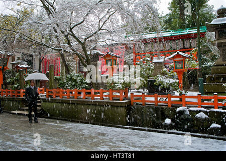 Uomo giapponese con il bianco ombrello in tempesta di neve a Yasaka sacrario scintoista a Kyoto in Giappone. Foto Stock