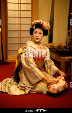 La geisha si prepara per intrattenere un gruppo in un ristorante, il quartiere di Gion, Kyoto in Giappone. Foto Stock