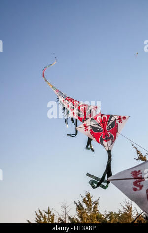 Fila di carta cinese volare aquiloni sul cielo blu chiaro Foto Stock