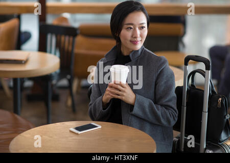 Imprenditrice in attesa in aeroporto Foto Stock