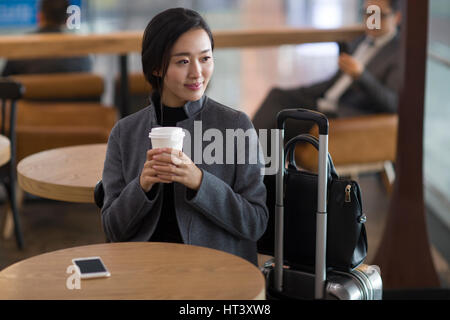 Imprenditrice in attesa in aeroporto Foto Stock