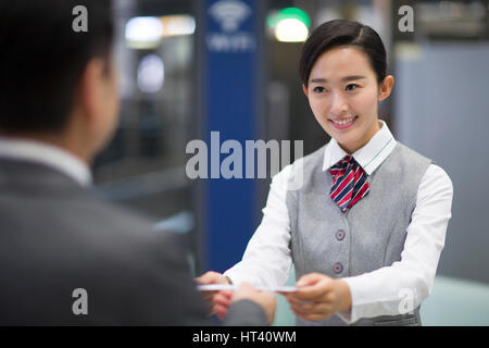 Sorridenti hostess della compagnia aerea e il passeggero Foto Stock