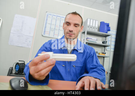 Uomo in ufficio con lampadina Foto Stock