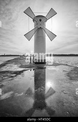 Swinoujscie, Polonia - 25 Febbraio 2017: Beacon windmill Stawa Mlyny, punto di riferimento della città contro il sole. Foto Stock