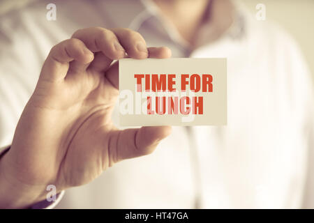 Primo piano su imprenditore tenendo una scheda con il testo del tempo per il pranzo, business Concetto di immagine con soft focus background e tono vintage Foto Stock