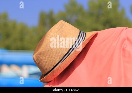 La paglia trilby hat sul soleggiato lato piscina con maglia rosa Foto Stock