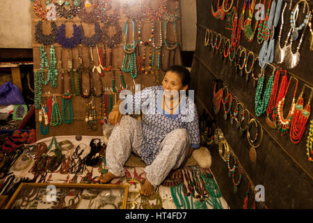 Donna vendita di diversi tipi di gioielli al sabato notte di mercato in Arpora, India. Il mercato è aperto ogni sabato durante la stagione turistica. T Foto Stock