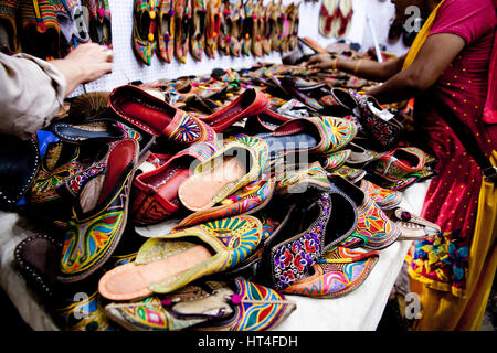 Calzatura venditore al sabato notte di mercato in Arpora, India. Il mercato è aperto ogni sabato durante la stagione turistica. Vi è una grande selezione di Foto Stock