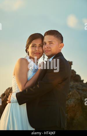 Ritratto di felice giovani coppie in viaggio di nozze su Blu Cielo di tramonto sullo sfondo. Abbraccio sposa e lo sposo Foto Stock