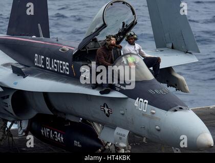 Stati Uniti i marinai di eseguire le operazioni di manutenzione su un U.S. Navy F/A-18 Hornet fighter aircraft sul ponte di volo a bordo della USN Nimitz-class portaerei USS Carl Vinson Febbraio 18, 2017 in stretto di Luzon. Foto Stock