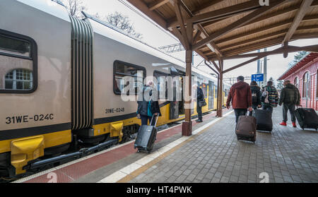 Szklarska Poreba, Polonia - Febbraio 2017 : i turisti con Borsoni con ruote casi imbarco pronto alla partenza treno locale in piedi su una piattaforma su tr Foto Stock