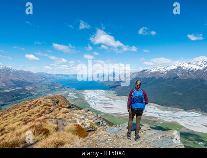 Escursionista affacciato sul lago Wakatipu dal Monte Alfred, Glenorchy a Queenstown, Alpi del Sud,, Otago Southland, Nuova Zelanda Foto Stock