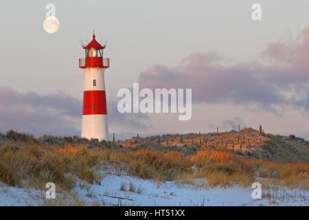 Rosso e bianco striato elenco faro est nelle dune durante la luna piena, crepuscolo ellenbogen, elenco, Sylt, Frisia settentrionale Foto Stock