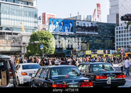 TOKYO, Giappone - 24 ottobre 2016: Classic taxi auto in Shibuya quartiere dello shopping con la folla di persone Foto Stock