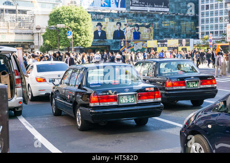 TOKYO, Giappone - 24 ottobre 2016: Classic taxi auto in Shibuya quartiere dello shopping con la folla di persone Foto Stock