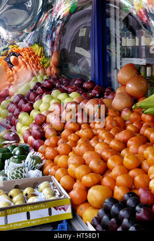 Kentish Town shop con al di fuori di stallo di frutta arance e mele pesche limoni Foto Stock