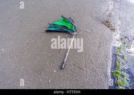 Scartato ombrello rotta sul terreno. Foto Stock