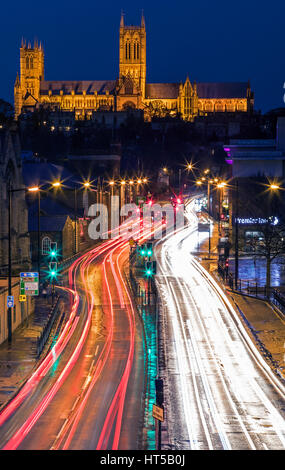 LINCOLN, Regno Unito - Febbraio 2017: una vista della Cattedrale di Lincoln che si affaccia su sentieri di luce dal traffico nella storica città di Lincoln, nel Regno Unito il 27 feb. Foto Stock