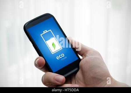 Uomo con telefono economico con modalità batteria sul display Foto Stock