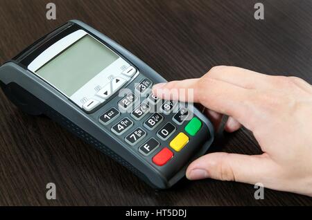 Man mano utilizzando il terminale di pagamento in un negozio Foto Stock