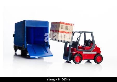 Carrello elevatore a forche giocattoli con le caselle. Concetto di trasporto internazionale di merci Foto Stock