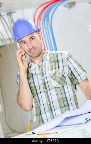 L'uomo sul telefono al sito in costruzione Foto Stock