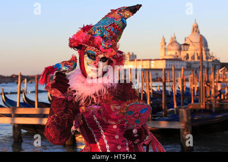 Una mascherata signora vestita come una strega al di fuori della chiesa di Santa Maria della Salute, durante il Carnevale di Venezia, Italia Foto Stock