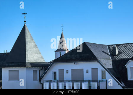 WINTERBERG, Germania - 16 febbraio 2017: tetto della torre di una chiesa e degli edifici circostanti a Winterberg Foto Stock