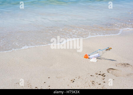 Un messaggio in bottiglia in riva al mare Foto Stock
