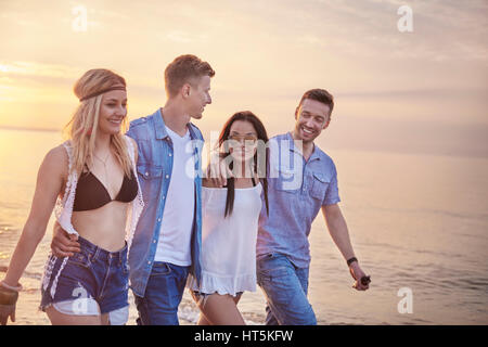 Camminare sulla spiaggia al tramonto Foto Stock